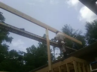 Carpenter setting a ridge beam over a new addition frame — Ice Dam Removal by Roofing Brothers in Cochranville