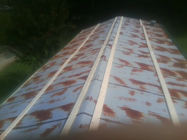 Rusted metal roof panels with new wood purlins before replacement — Storm Damage Roof Repair in Cochranville by Roofing Brothers