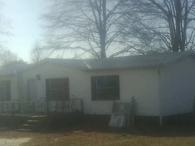 New metal roof on a white painted brick home on a foggy morning in Cochranville